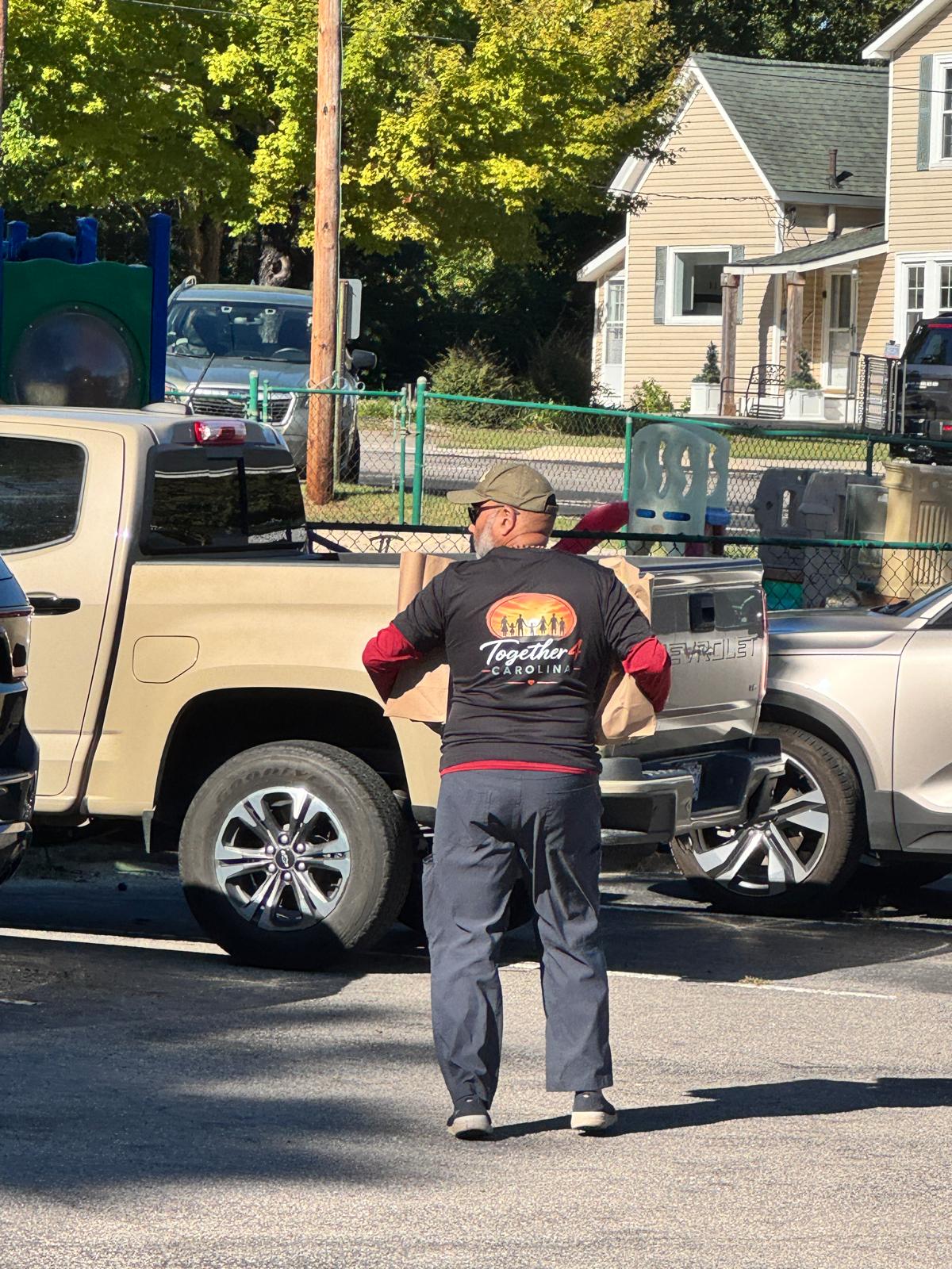 Together 4 Carolina volunteer carrying grocery bags for families in Zebulon